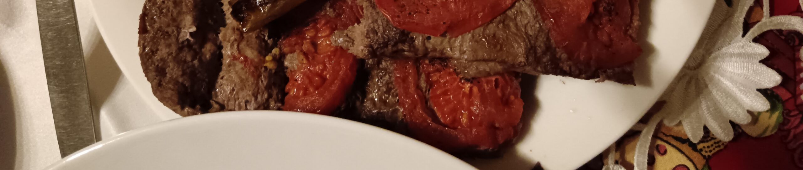 Мясо по-сирийски с запечёнными помидорами и перцем: сочные куски, золотистая корочка, след пальца на краю тарелки — бесплатно скачайте фото.